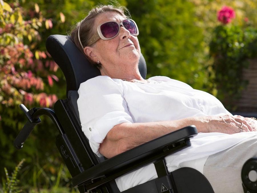 Eine Dame in einem Rollstuhl von Etac. Eine Dame in einem Rollstuhl von Etac.