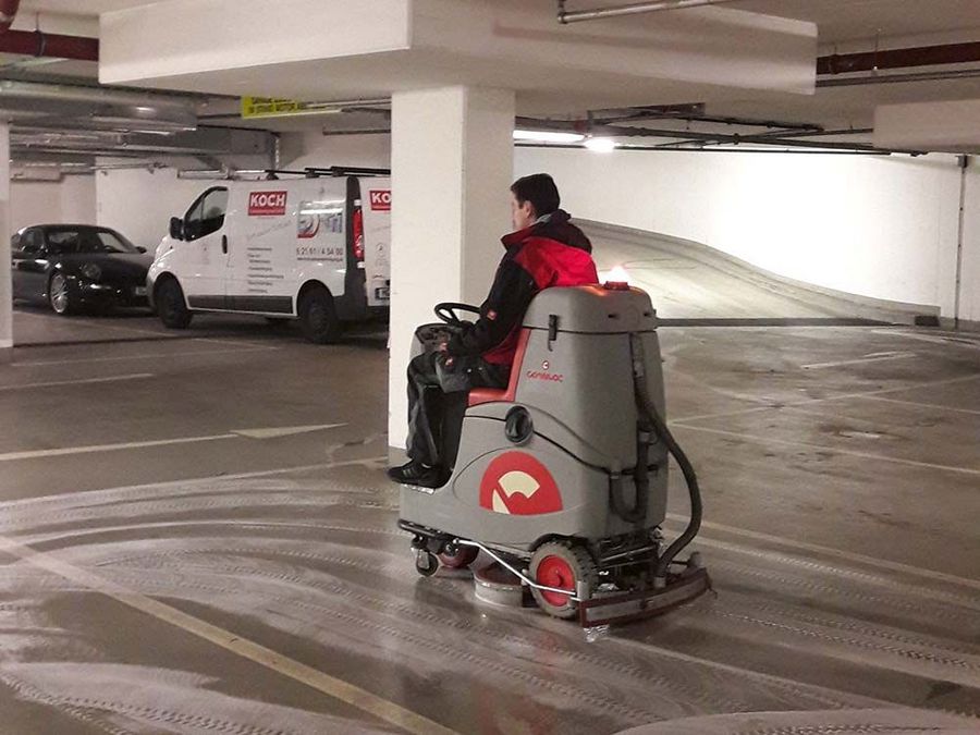 Koch-Mitarbeiter auf einer Bodenreinigungsmaschine Koch-Mitarbeiter auf einer Bodenreinigungsmaschine