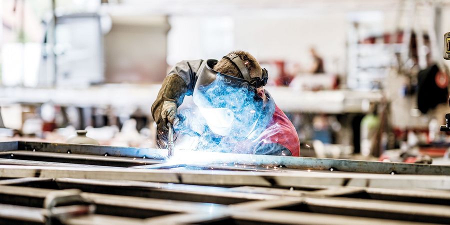 Präzise Handwerkskunst: Ein Mitarbeiter beim Schweißen Präzise Handwerkskunst: Ein Mitarbeiter beim Schweißen